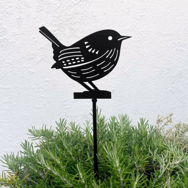The Recycled Metal Robin Silhouette Garden Stake is shown among lush green foliage, set against a plain white wall.