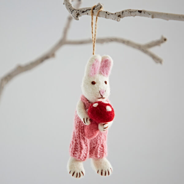 The Felt Rabbit with Toadstool Hanging Decoration features a cute bunny in pink dungarees holding a red and white toadstool, perfect for hanging on a bare branch.