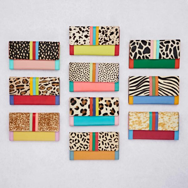 Twelve Hema Multicoloured Recycled Leather Clutch Purses with animal prints and colourful stripes are arranged in three rows on a light background.