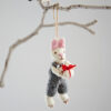 The Felt Rabbit with Gift Hanging Decoration features pink ears, a grey outfit, and holds a red and white present, making it a charming addition to any tree or branch.