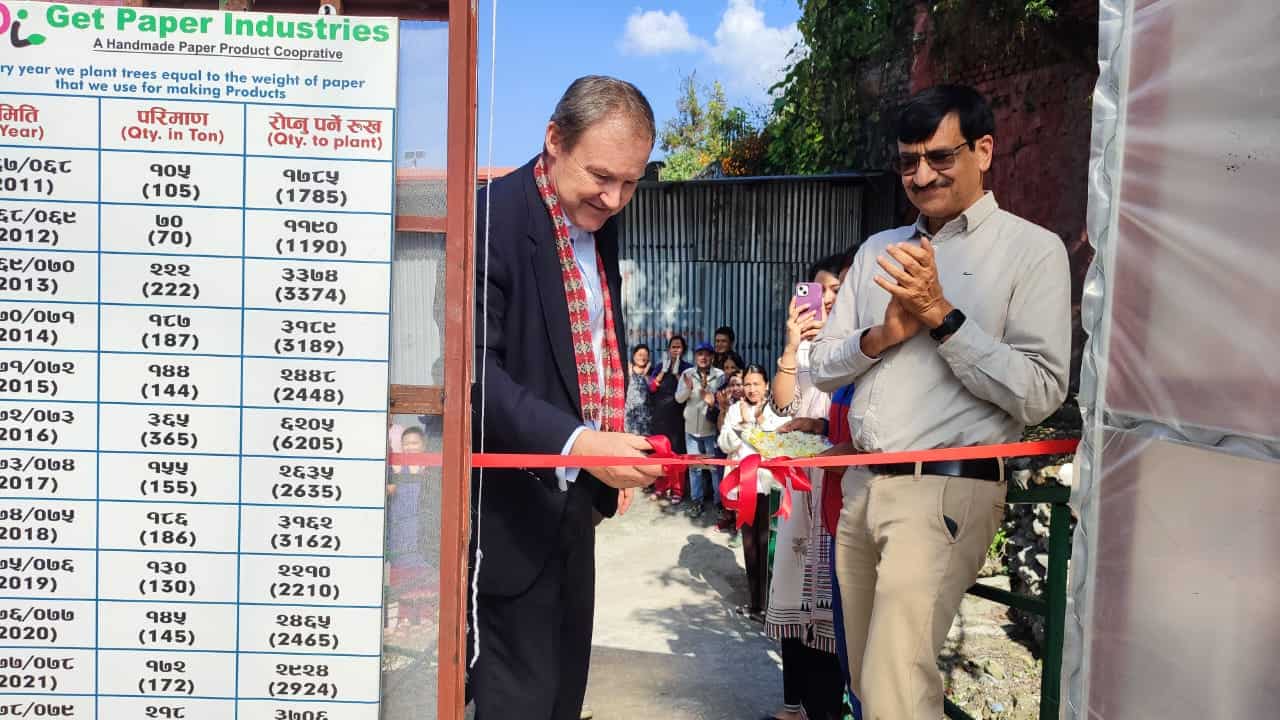Rob Fenn, British Ambassador to Nepal, cuts a red ribbon to mark the opening of the new Get Paper Industries sapling nursery, with founder Milan.