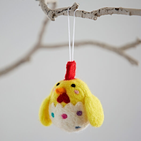 The Felt Chick in Egg Hanging Decoration features yellow wings, a red crest, and hangs from a white string on a bare twig.