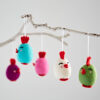 Five Felt Easter Chick Hanging Decorations, each with a red comb and unique facial expression, hang from a white branch.