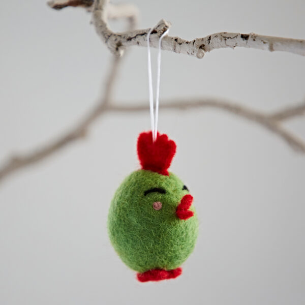 The Felt Easter Chick Hanging Decoration is a small green ornament with red accents, hanging from a white branch by a white string.